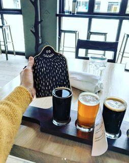 A Lyle held up in front of Mikkeller DTLA